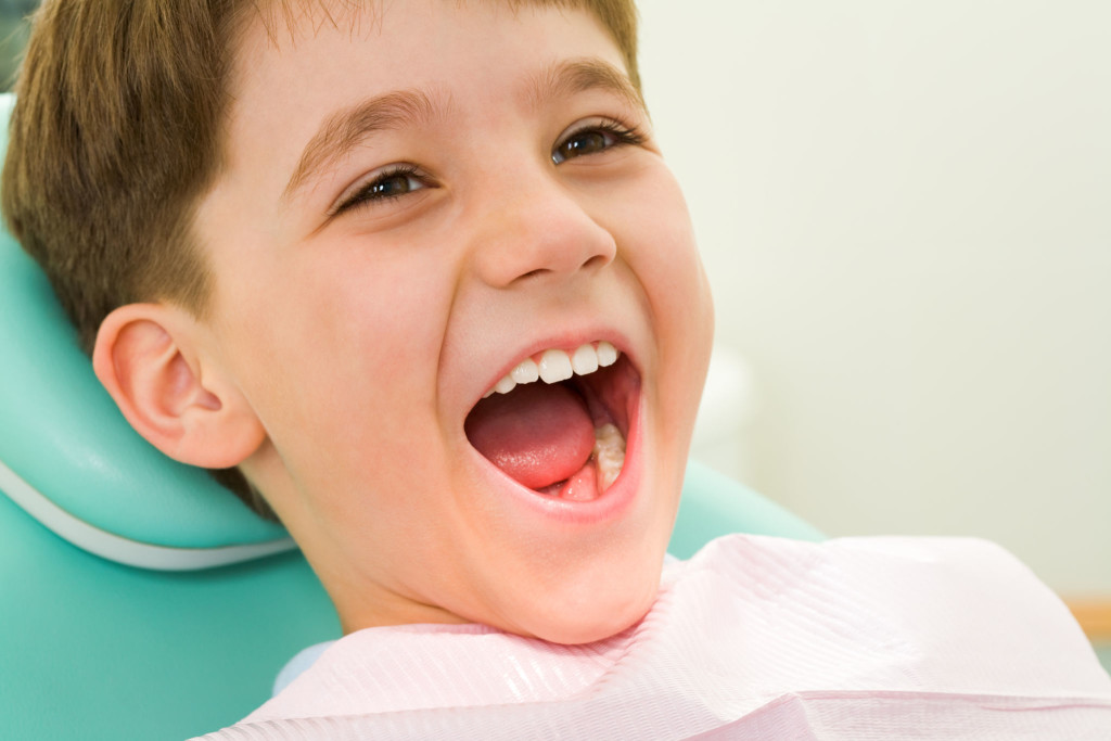 Zadowolony chłopiec u stomatologa dziecięcego
