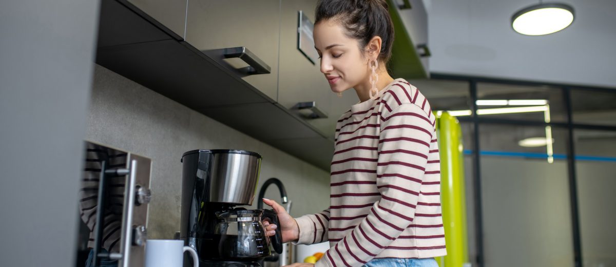 young-woman-preparing-coffee-in-the-kitchen-846fxle-1200x520.jpg