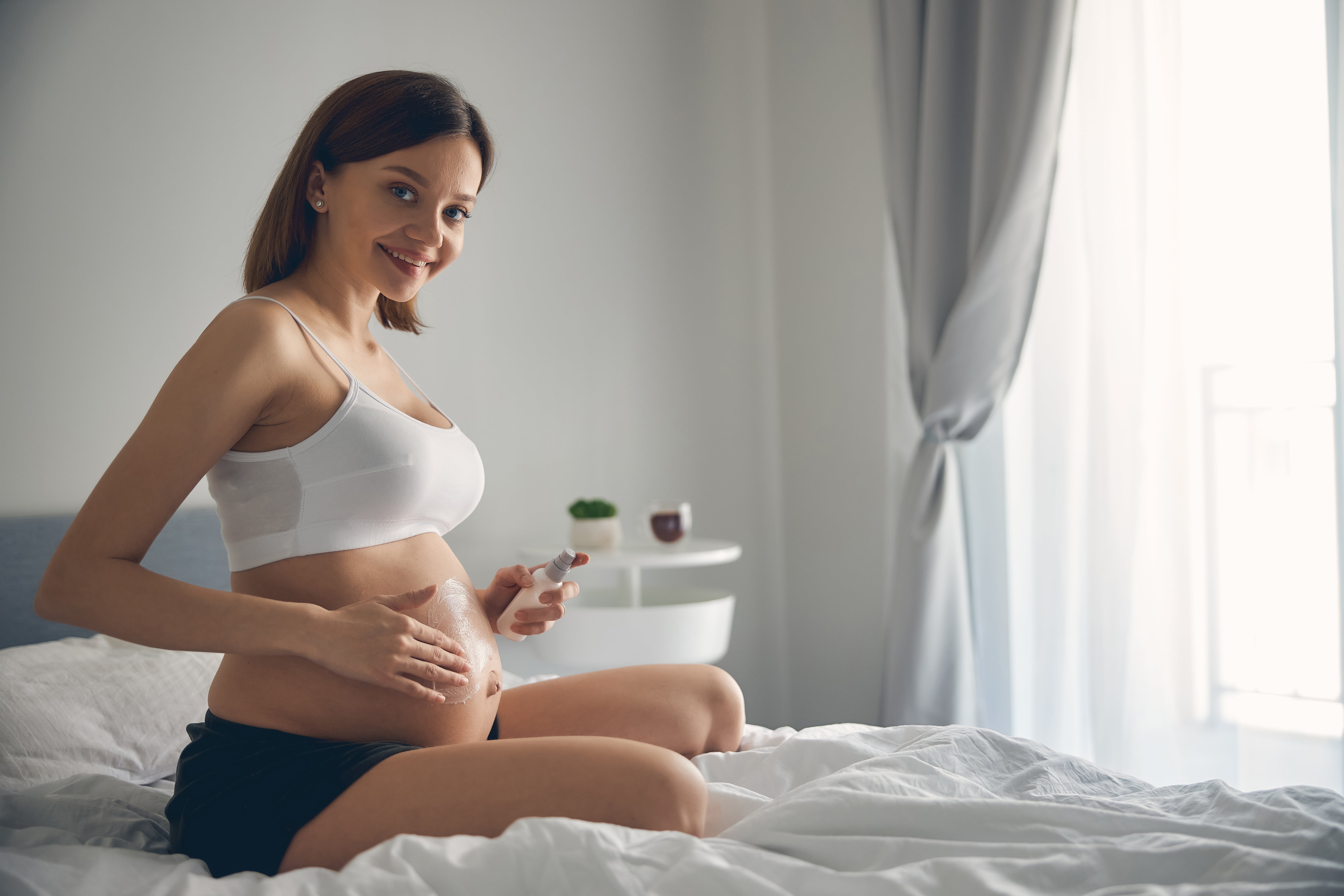 woman-lubricating-and-moisturizing-pregnant-belly-------utc-min