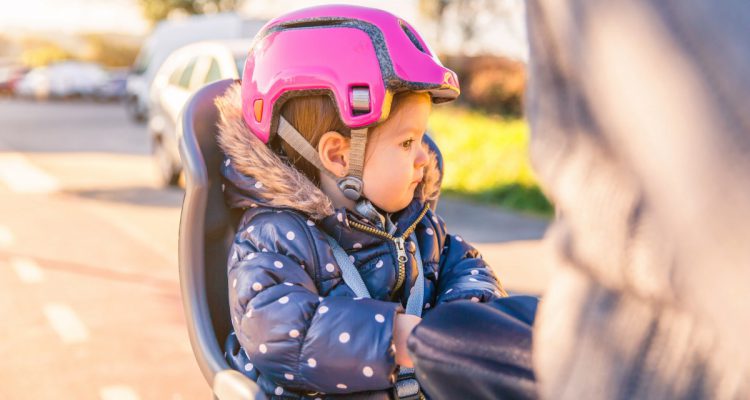 little-girl-with-helmet-on-head-sitting-in-bike-se-------utc