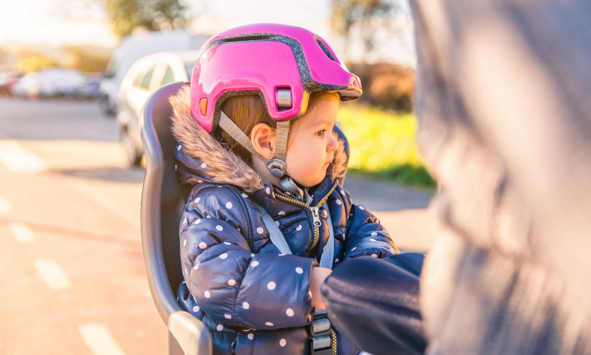 little-girl-with-helmet-on-head-sitting-in-bike-se-------utc