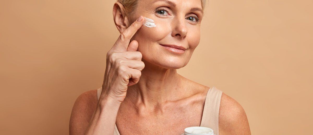 middle-aged-beautiful-woman-applies-anti-aging-cream-on-face-undergoes-beauty-treatments-cares-about-skin-1200x520.jpg