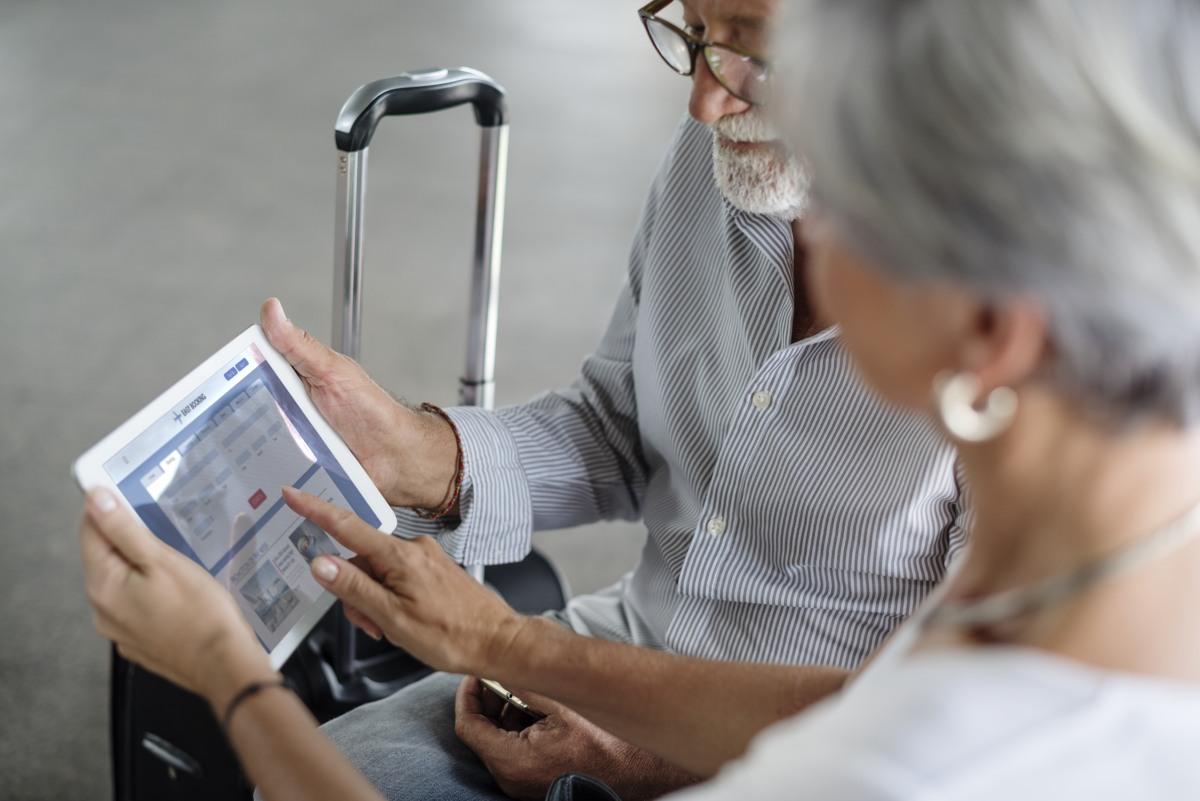 para seniorów w podróży szuka odpowiedniego noclegu na tablecie