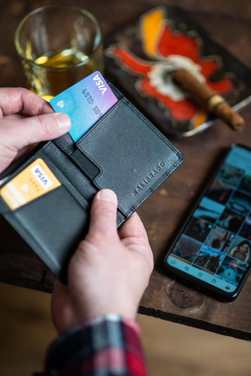 dłonie trzymają portfel z kartami kredytowymi