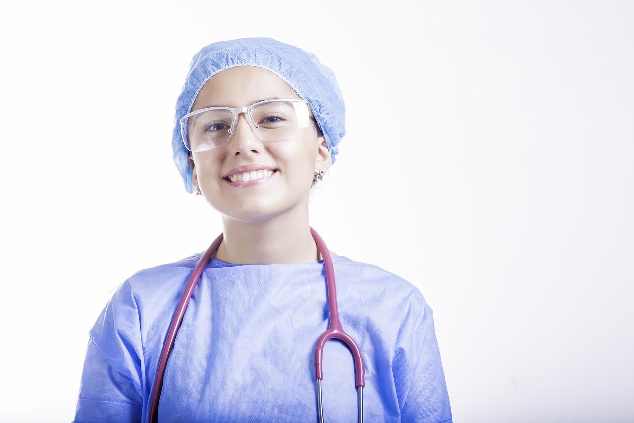 młoda pielęgniarka w niebieskim stroju i stetoskopem na szyi