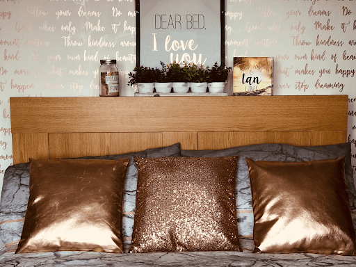Sypialnia, łóżko, poduszki, ściana z namalowanymi napisami
