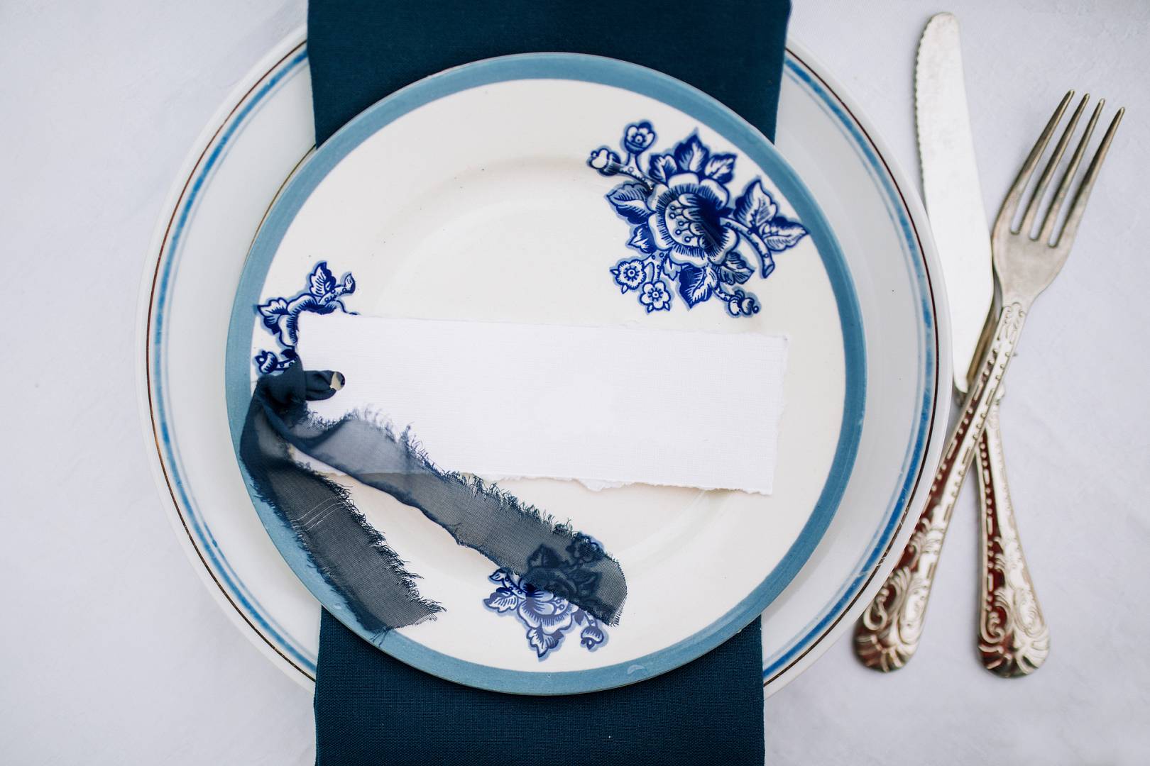 porcelain plate with a blue pattern on which lies a white card a