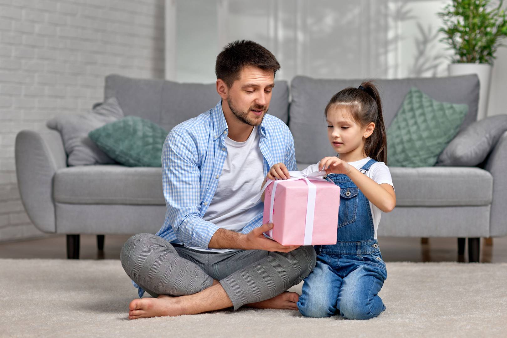 daughter congratulates father and gives him gift box.