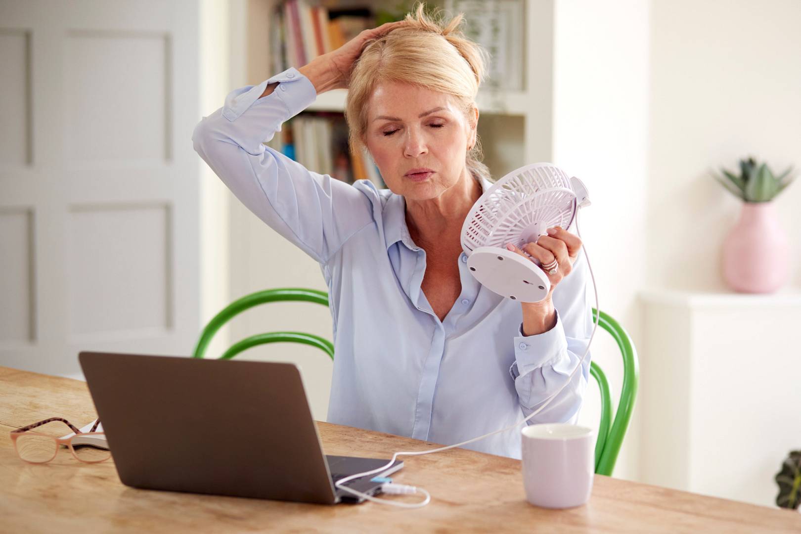 Menopausal Mature Woman Having Hot Flush At Home Cooling Herself