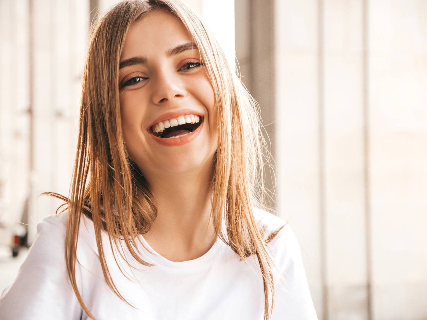 Portrait of beautiful smiling blond model dressed in summer hipster clothes. Trendy girl posing in the street background. Funny and positive woman having fun