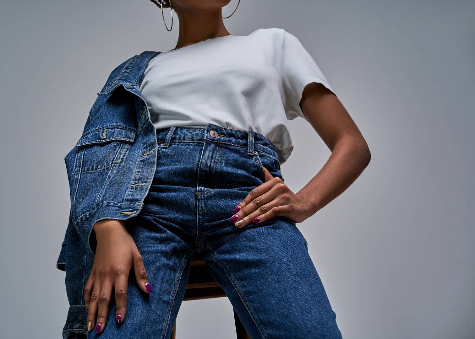 Girl in white t shirt in jeans with denim jacket posing on camer