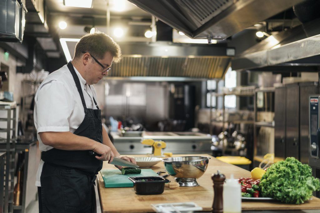 side view male chef kitchen preparing vegetables