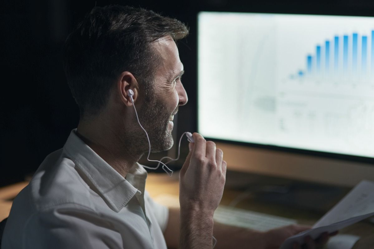 Side view of man listening to music in his office