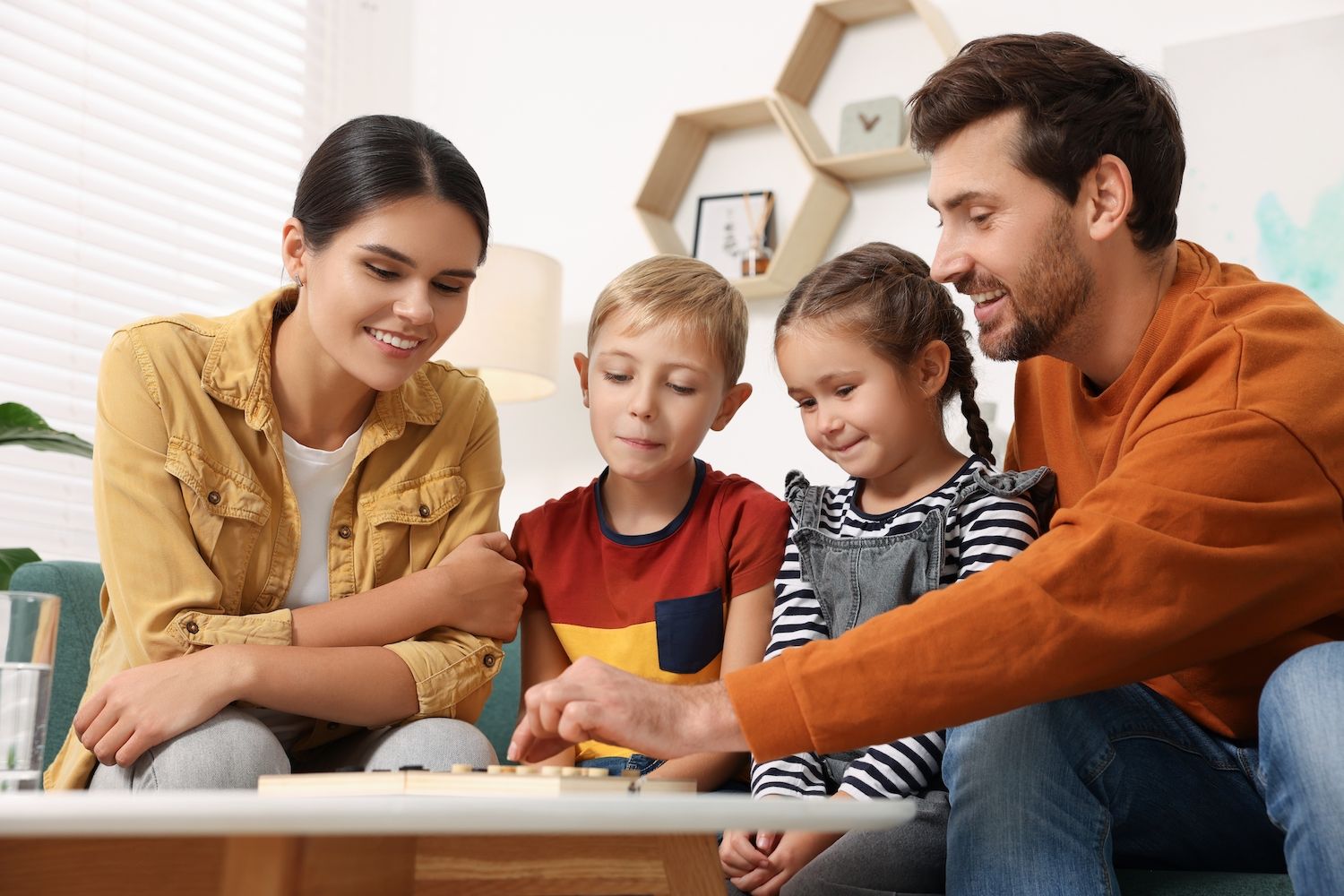 Family,Playing,Checkers,At,Coffee,Table,In,Room
