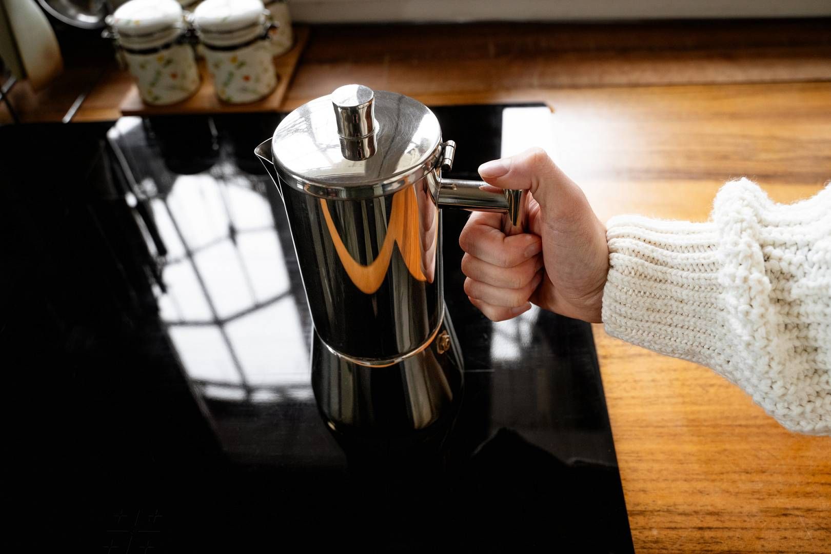 Top view of a woman's hand preparing coffee using a classic geys