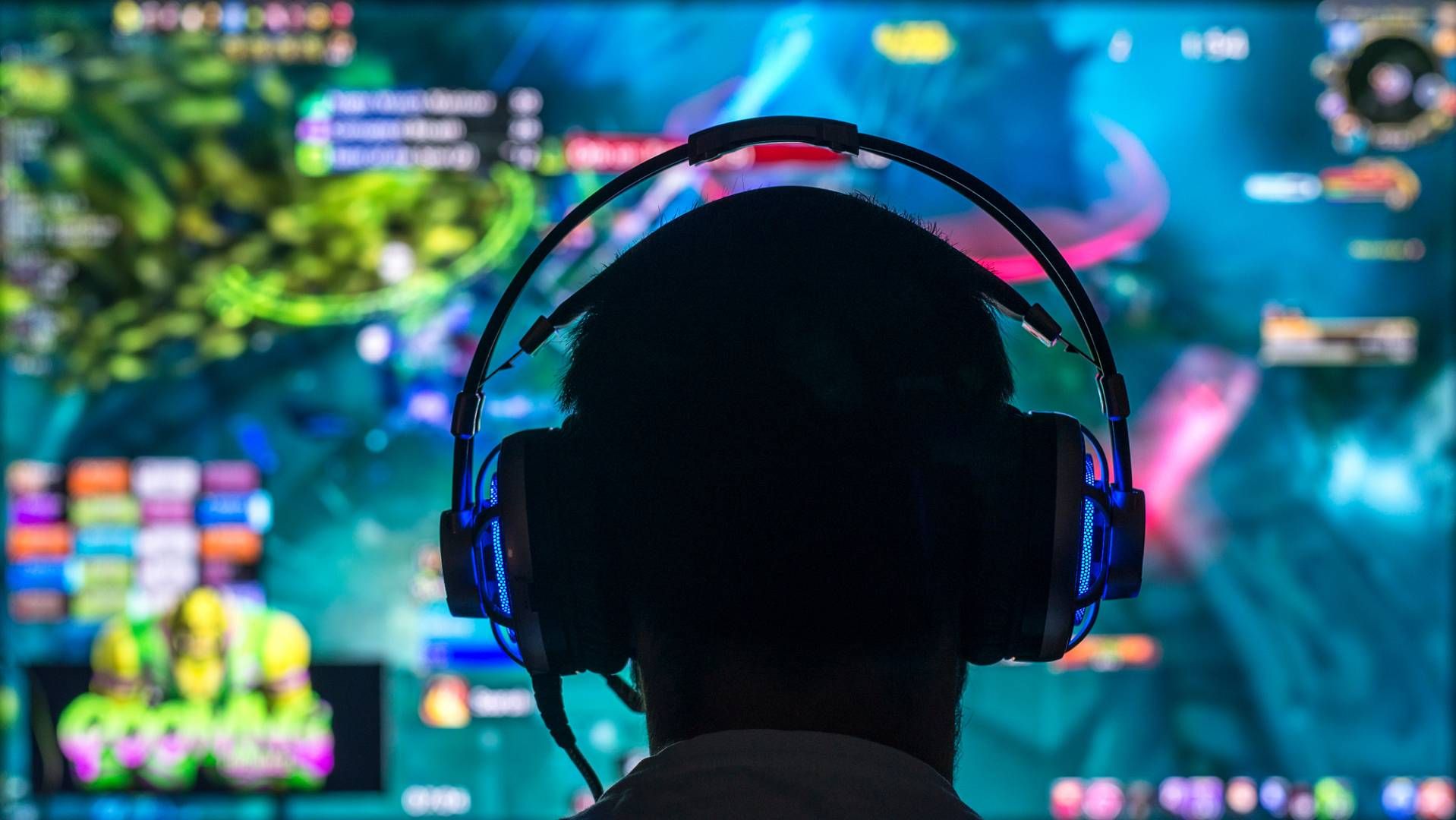 Young gamer playing video game wearing headphone.