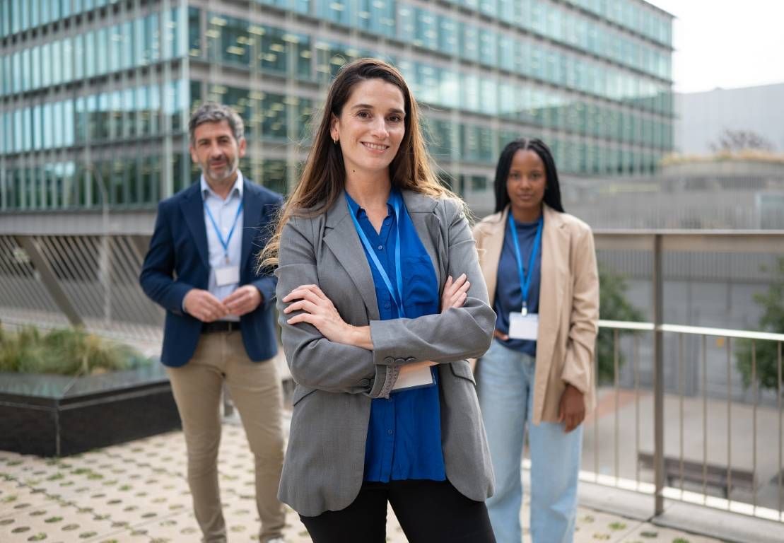 Businesspeople posing outdoors with their leader in front