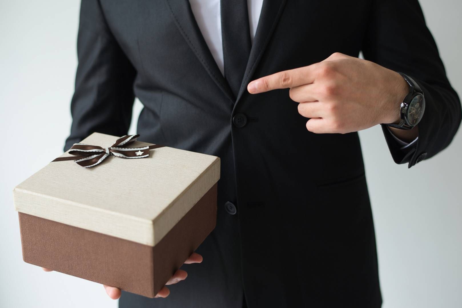 unrecognizable businessman holding brown gift box wp